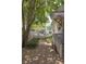 The side yard has mature trees, landscaping, gravel, and a partial fence that adds character to the home at 5010 Converse St, North Charleston, SC 29405