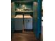 Laundry closet with stacked washer and dryer, convenient shelving, and matching blue trim at 5010 Converse St, North Charleston, SC 29405