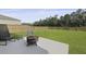 Patio area with fire pit, lounge seating, large lawn, and wooded privacy fence at 505 Spanish Wells Road Rd, Summerville, SC 29486