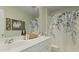 Well lit bathroom with floral shower curtain, framed wall art, and white cabinets and countertop at 505 Spanish Wells Road Rd, Summerville, SC 29486