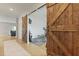 Bonus room featuring sliding barn doors, hardwood floors, leading to a separate room with workout equipment at 505 Spanish Wells Road Rd, Summerville, SC 29486