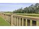 Scenic view of a pond with lush trees, bordered by a well-maintained wooden fence at 505 Spanish Wells Road Rd, Summerville, SC 29486