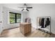 Bright bedroom with natural light, ceiling fan, wood floors, black window trim and wardrobe racks at 518 Woodward Blvd, Summerville, SC 29483