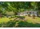 Spacious backyard featuring a fire pit, lush lawn, and mature trees at 5302 Helene Dr, North Charleston, SC 29418