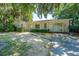Charming one-story brick home with attached carport, lush landscaping, and mature trees at 5302 Helene Dr, North Charleston, SC 29418