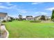 Expansive backyard with lush green lawn, neighboring homes, and mature trees at 554 Tidewater Chase Ln, Summerville, SC 29486