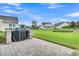 Exterior view of outdoor kitchen with stone grill, overlooking landscaped yard and neighboring homes at 554 Tidewater Chase Ln, Summerville, SC 29486