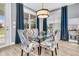 Dining room with glass table, upholstered chairs, modern light fixture, and wood floors at 554 Tidewater Chase Ln, Summerville, SC 29486