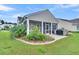 Exterior view of home's screened-in porch, manicured landscaping, and well-maintained yard at 554 Tidewater Chase Ln, Summerville, SC 29486