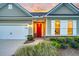 Inviting front porch with brick-paved walkway and red door complemented by manicured shrubbery and green lawn at 554 Tidewater Chase Ln, Summerville, SC 29486