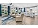 Open-concept living room with hardwood floors, modern furnishings, and seamless flow into the bright, white kitchen at 554 Tidewater Chase Ln, Summerville, SC 29486