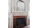 Living room fireplace with brick surround, decorative mirror, and white mantel providing a cozy focal point at 623 Bay Tree Ct, Mount Pleasant, SC 29464