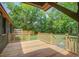 A back deck with wood railing overlooking a spacious yard filled with mature trees and greenery at 670 Dupre Rd, McClellanville, SC 29458