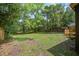 Large, grassy backyard with mature trees providing shade and privacy around the home at 670 Dupre Rd, McClellanville, SC 29458
