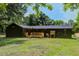 Back exterior of the home showcasing a wooden deck and ample backyard space with mature trees at 670 Dupre Rd, McClellanville, SC 29458