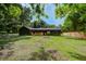 Exterior view of the home with a spacious backyard, featuring a wooden deck and new fencing at 670 Dupre Rd, McClellanville, SC 29458