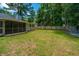 Spacious backyard with a screened porch, lawn, and wooden privacy fence at 687 Ponderosa Dr, Charleston, SC 29414