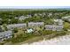 Aerial view of the community buildings featuring a pool, trees, beach, and a walking path at 7 Beach Club Villas, Isle of Palms, SC 29451