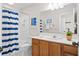 A bathroom featuring a blue-striped shower curtain and a wooden vanity at 7 Beach Club Villas, Isle of Palms, SC 29451