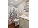 Stylish bathroom with an octopus shower curtain, round mirror, and ample lighting at 7 Beach Club Villas, Isle of Palms, SC 29451