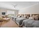 This comfortable bedroom includes three beds, light walls, ceiling fan, and a wicker chair and ottoman at 7 Beach Club Villas, Isle of Palms, SC 29451