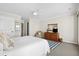 A bright bedroom with a ceiling fan, white bedding, and a wooden dresser at 7 Beach Club Villas, Isle of Palms, SC 29451