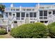 Rear exterior view of multilevel white townhouse with private entry stairs and beautiful landscaping at 7 Beach Club Villas, Isle of Palms, SC 29451