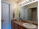Well-lit bathroom with a large mirror over the vanity, and a view into another room at 7322 Stoney Moss Way, Hanahan, SC 29410