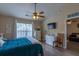 Cozy bedroom features a ceiling fan and a view into the living room at 7322 Stoney Moss Way, Hanahan, SC 29410