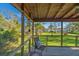 Cozy screened porch with a chair and view of the landscaped backyard at 7897 Russell Creek Dr, Edisto Island, SC 29438