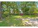 A vast backyard featuring lush green grass, mature trees, and a charming swing, offering a serene outdoor experience at 8475 N Scotts Mill Dr, North Charleston, SC 29420