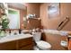 Cozy bathroom with a wood vanity, white sink, toilet, and decorative accents, creating a functional and stylish space at 8475 N Scotts Mill Dr, North Charleston, SC 29420