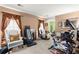 A versatile bonus room featuring carpet flooring, large windows, and a home gym setup at 8475 N Scotts Mill Dr, North Charleston, SC 29420