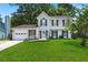 Charming two-story home featuring a well-manicured lawn, inviting front porch, and classic architectural details at 8475 N Scotts Mill Dr, North Charleston, SC 29420