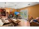 Cozy living room with brick fireplace, ceiling fan, TV, parquet floors, and a glass panel door at 8475 N Scotts Mill Dr, North Charleston, SC 29420