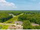 Aerial view of townhomes nestled within lush, green surroundings and scenic landscape with a pond at 854 Bibury Ct, Charleston, SC 29414