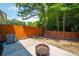 A quaint backyard features a stone patio and a fire pit, enclosed by a wooden fence, perfect for outdoor relaxation at 854 Bibury Ct, Charleston, SC 29414