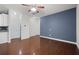 Open-concept living room featuring hardwood floors, white walls, a ceiling fan and access to the kitchen at 854 Bibury Ct, Charleston, SC 29414