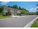 Picturesque street view shows colorful townhomes with mature trees and landscaping, creating a charming and inviting neighborhood atmosphere at 854 Bibury Ct, Charleston, SC 29414