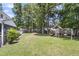 Large backyard with lush greenery, wooden swing set, and privacy fence creating an ideal outdoor space at 9253 N Moreto Cir, Summerville, SC 29485