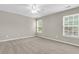 Bright, carpeted bedroom with neutral walls, ceiling fan, and natural light from two large windows at 9253 N Moreto Cir, Summerville, SC 29485