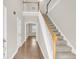 Welcoming foyer with hardwood floors, staircase with white railings, and plenty of natural light at 9253 N Moreto Cir, Summerville, SC 29485