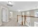 Upstairs loft area with neutral walls, carpet, wood railing, and several windows at 9253 N Moreto Cir, Summerville, SC 29485