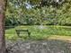 Scenic pond with fountain, surrounded by trees and featuring a tranquil bench for relaxation at 9253 N Moreto Cir, Summerville, SC 29485