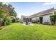 Backyard featuring expansive grassy area, landscaping, and a screened-in porch at 9616 Pebble Creek Blvd, Summerville, SC 29485