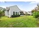 The home's backyard features lush lawn, meticulous landscaping, and screened-in porch at 9616 Pebble Creek Blvd, Summerville, SC 29485
