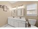 Bathroom with double sinks, white cabinets and tan walls at 9616 Pebble Creek Blvd, Summerville, SC 29485