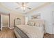 This bedroom features a ceiling fan, decorative tray ceiling, wood-look floors, and a large bed at 9616 Pebble Creek Blvd, Summerville, SC 29485
