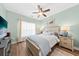 Bedroom with light green walls, wood look flooring, ceiling fan, and a large bed at 9616 Pebble Creek Blvd, Summerville, SC 29485