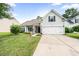 Charming home featuring a well-manicured lawn, two-car garage and classic American flag displayed on the front porch at 9616 Pebble Creek Blvd, Summerville, SC 29485